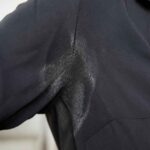 Zbliżenie czarnej koszuli z widocznym połyskiem materiału pod pachą